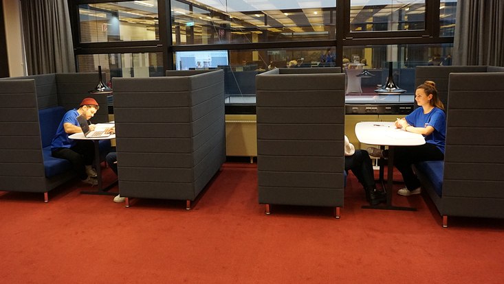 Studierende sitzen in der Stabi und schreiben.